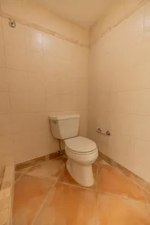 a white toilet sitting next to a white sink and vanity