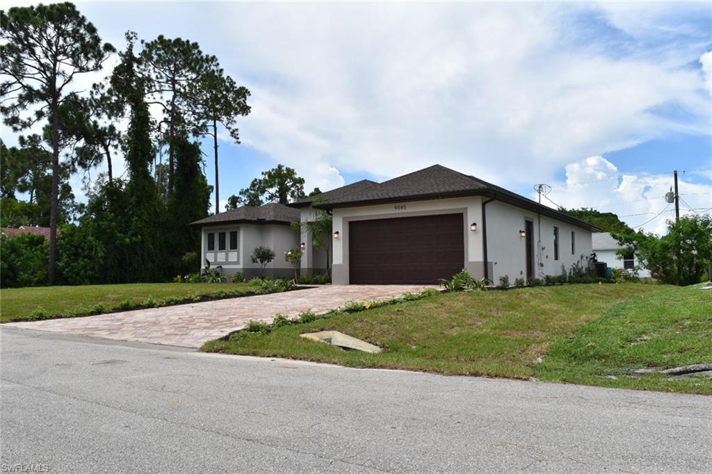 9045 Aster Road Fort Myers, FL 33967 - Photo 2 of 23 a front view of a house with a yard and garage