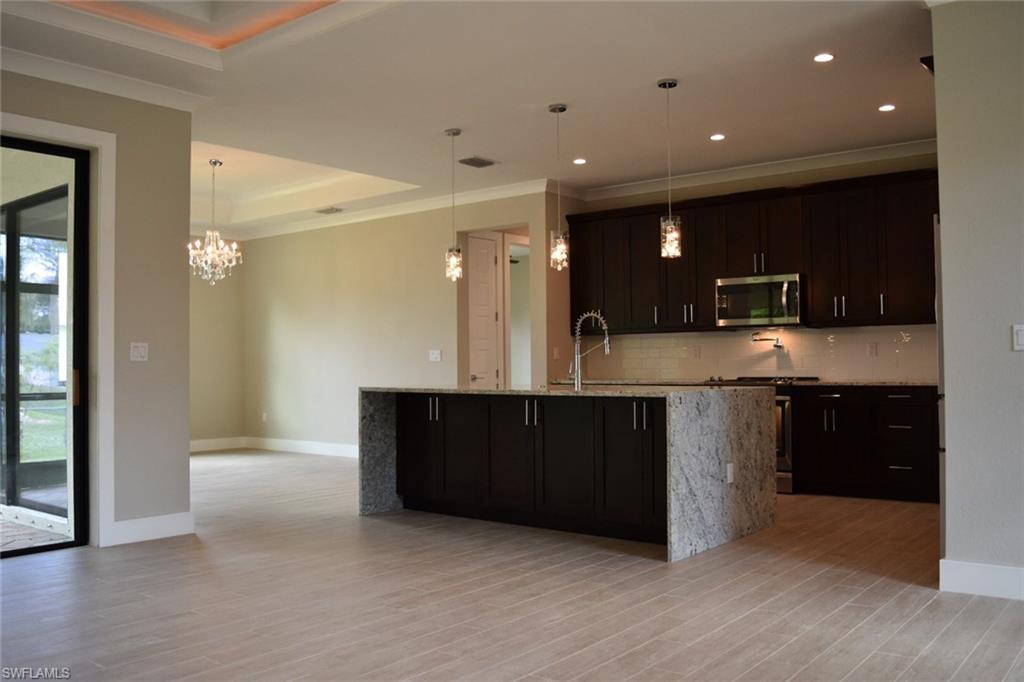 9045 Aster Road Fort Myers, FL 33967 - Photo 6 of 23 a large kitchen with stainless steel appliances granite countertop a large counter top and wooden floors
