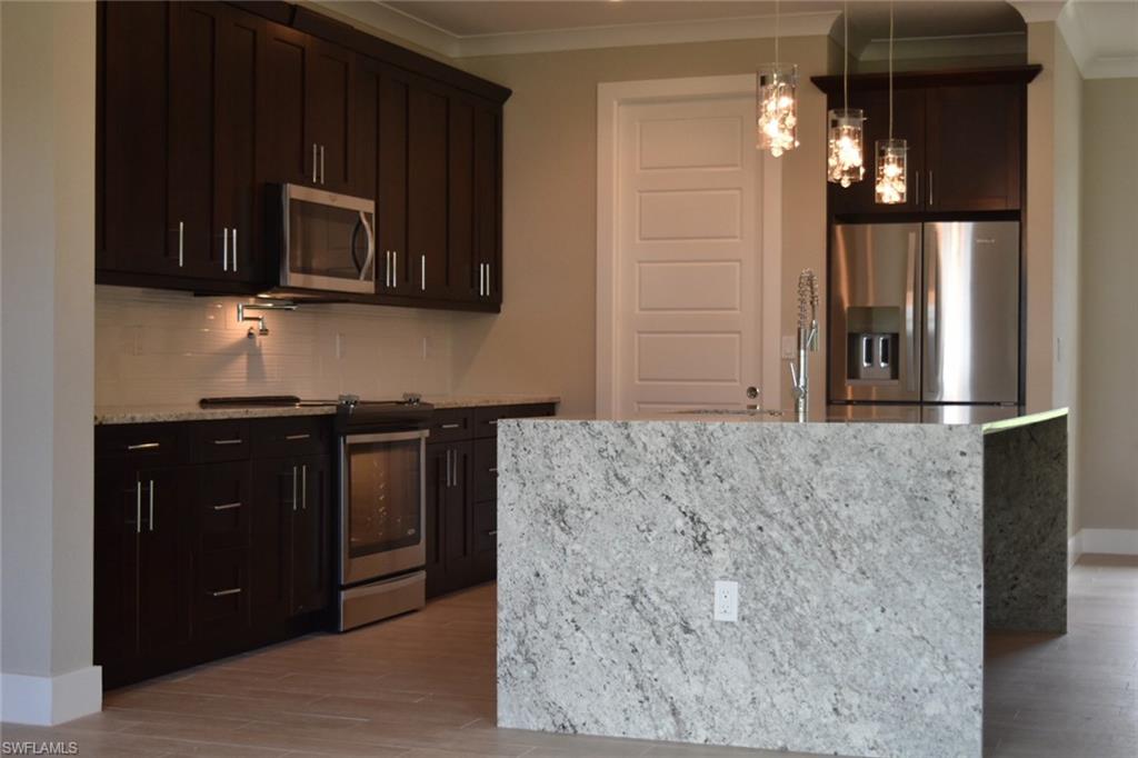 9045 Aster Road Fort Myers, FL 33967 - Photo 7 of 23 a kitchen with stainless steel appliances granite countertop a refrigerator and a microwave