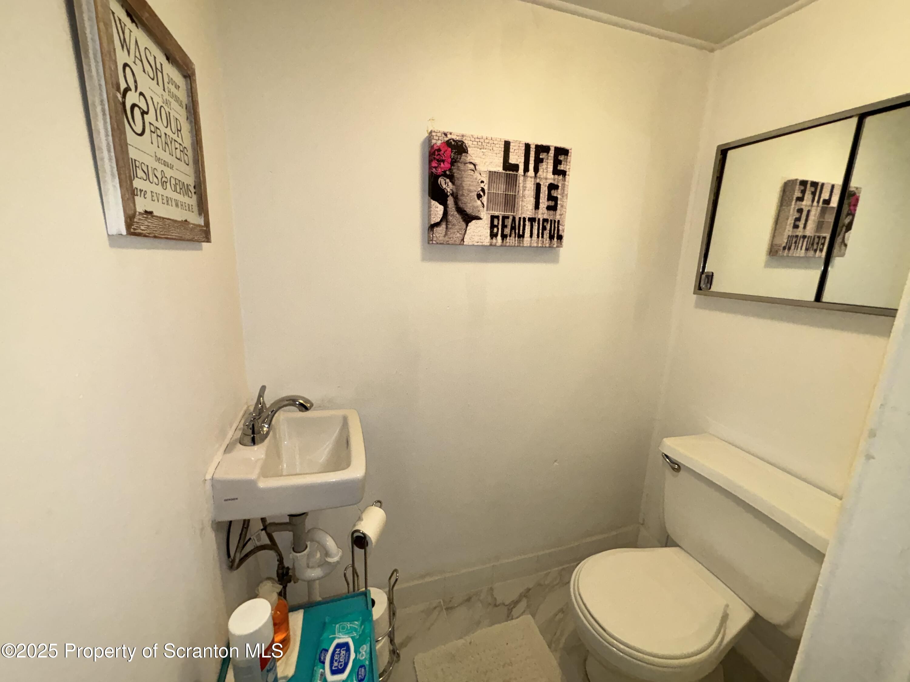 719 Saginaw Street Scranton, PA 18505 - Photo 13 of 23 a bathroom with a toilet sink and mirror