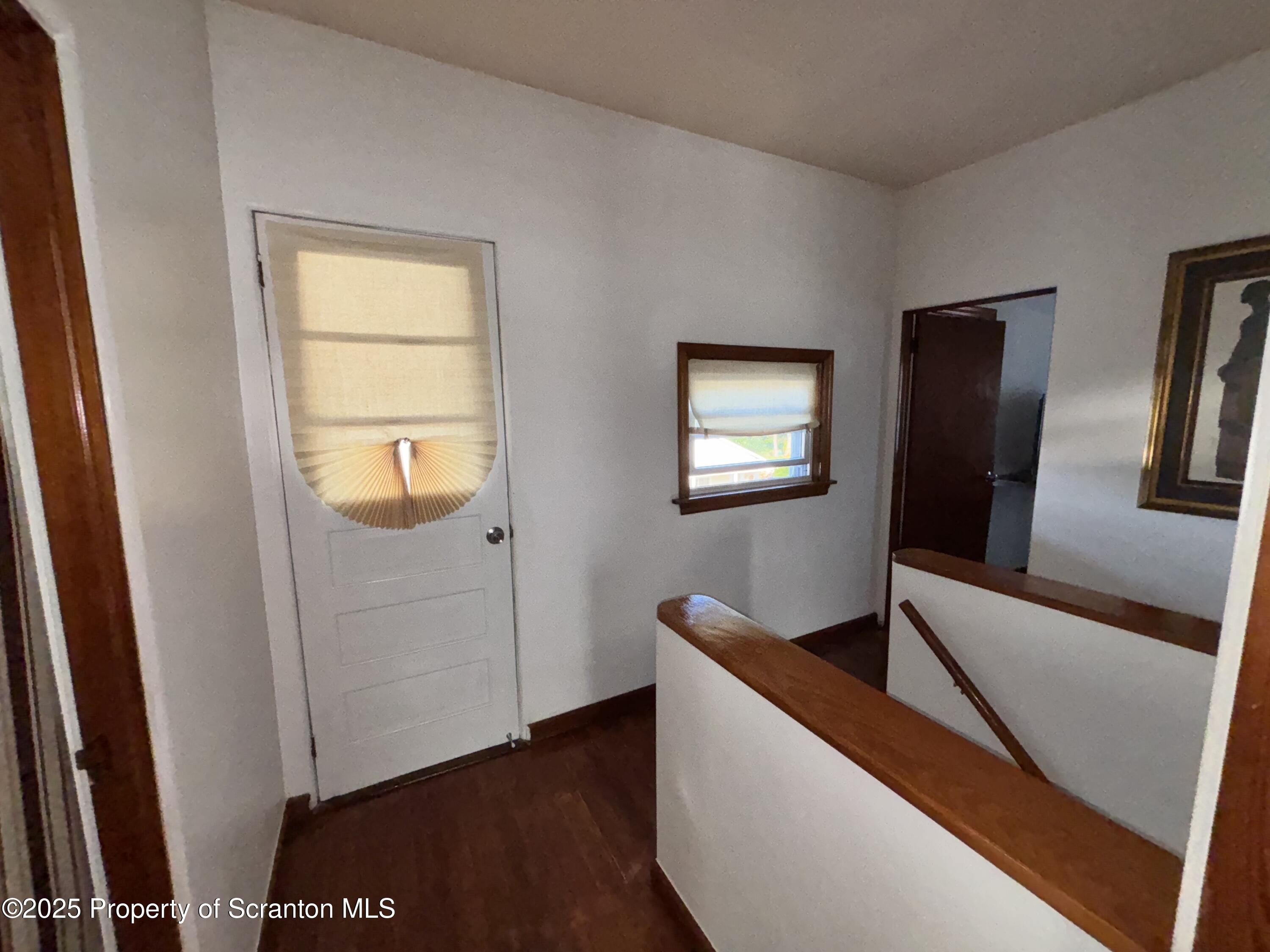 719 Saginaw Street Scranton, PA 18505 - Photo 20 of 23 a view of an empty room with wooden floor and a window