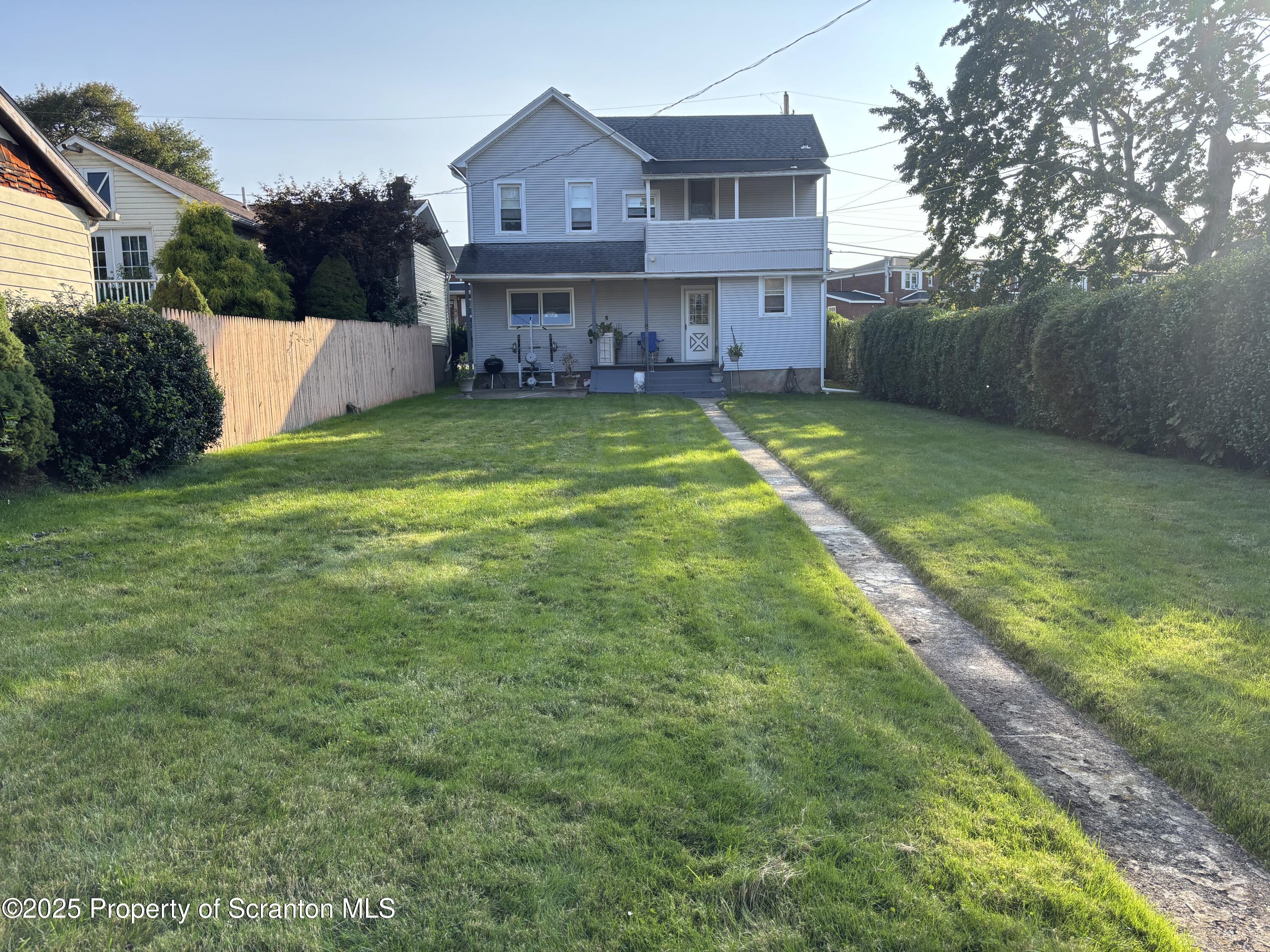 719 Saginaw Street Scranton, PA 18505 - Photo 22 of 23 a view of a house with a big yard and a large tree