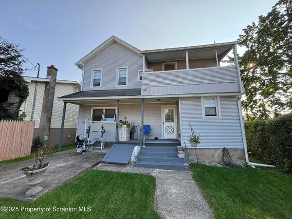a front view of a house with a yard and outdoor seating