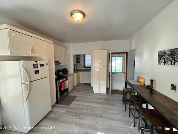 a kitchen with refrigerator cabinets and wooden floor