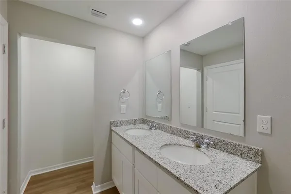a bathroom with a granite countertop sink and a mirror