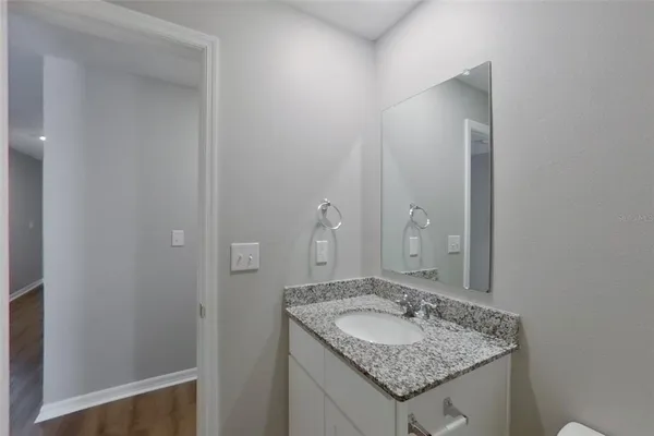 a bathroom with a granite countertop sink and a mirror