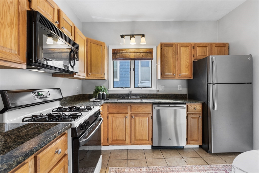 100 Pearl Street, Unit 2 Boston, MA 02129 - Photo 5 of 25 a kitchen with stainless steel appliances granite countertop a refrigerator stove top oven and sink