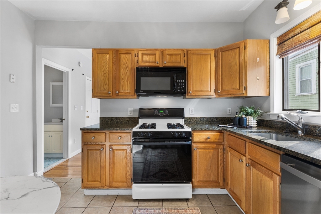 100 Pearl Street, Unit 2 Boston, MA 02129 - Photo 7 of 25 a kitchen with granite countertop a stove top oven microwave and cabinets