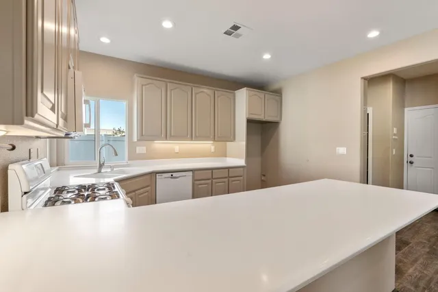 a kitchen with kitchen island granite countertop a sink cabinets and window
