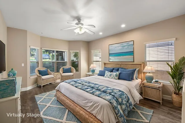 an empty room with windows a fireplace a ceiling fan and wooden floor
