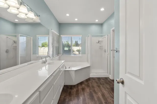 a bathroom with a bathtub a sink and a large mirror