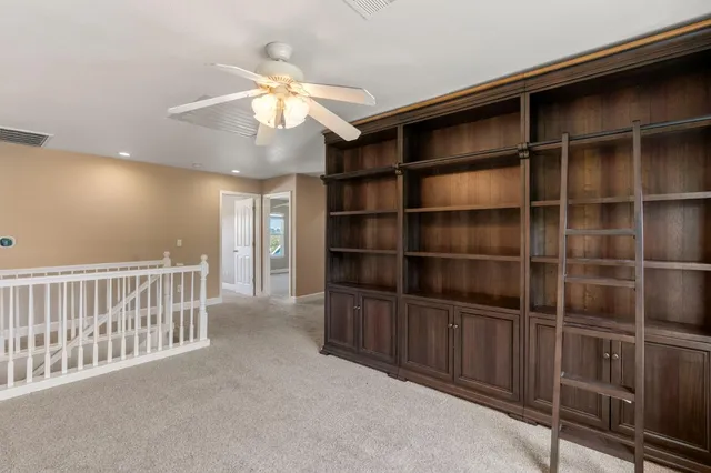 an empty room with windows and fan