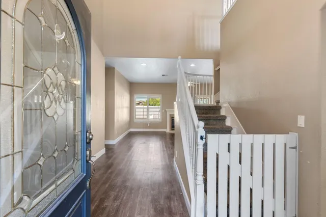 a view of a hallway with wooden floor and staircase