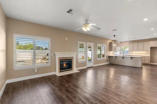 a view of an empty room with a kitchen and a window