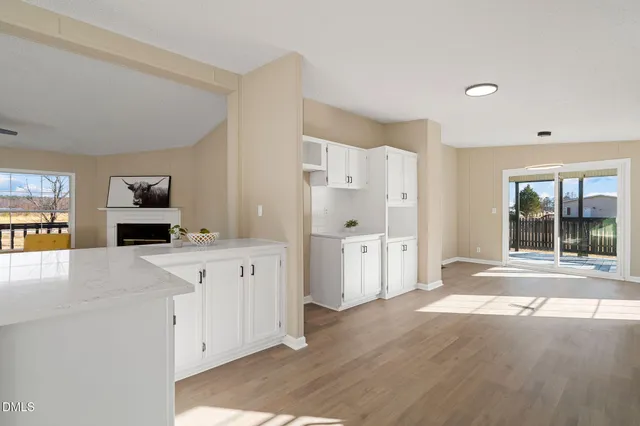 a kitchen with granite countertop a sink cabinets and wooden floor