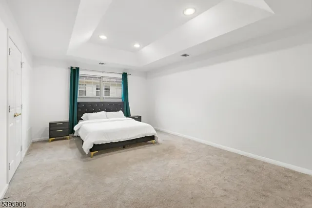 a spacious bedroom with a bed and a wall painting