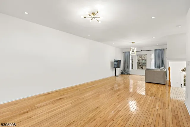 a view of a room with wooden floor and a ceiling fan