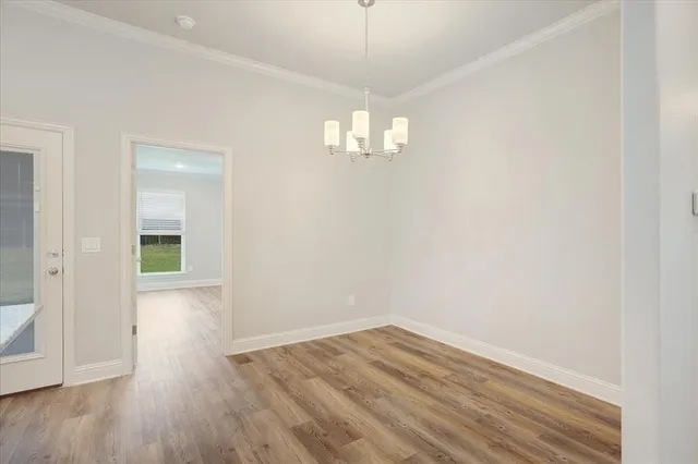 a kitchen with a refrigerator a stove a microwave oven a sink dishwasher and white cabinets with wooden floor