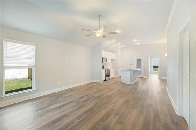 a view of a livingroom with a chandelier fan and wooden floor
