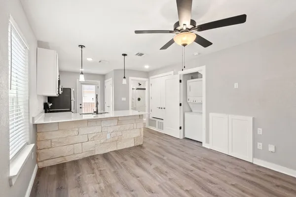 a large white kitchen with a large window stainless steel appliances
