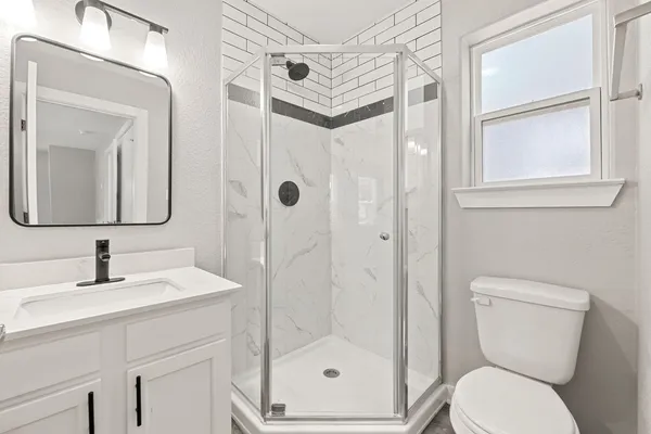a bathroom with a toilet sink shower and mirror