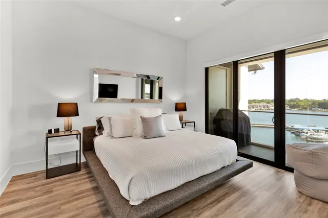 a bedroom with a large bed and a flat tv screen on dresser