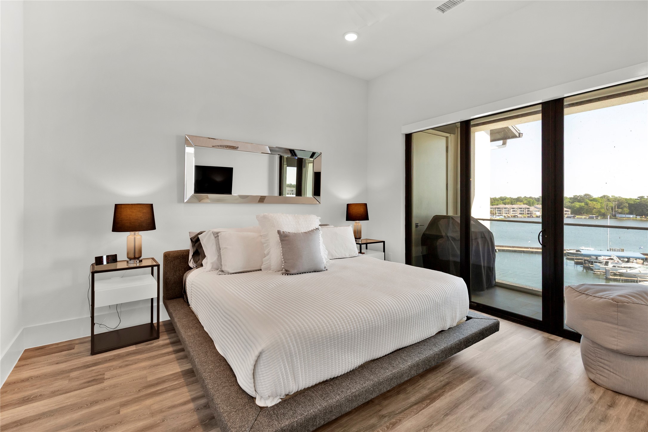 199 Waterpoint Court, Unit 412 Conroe, TX 77304 - Photo 14 of 29 a bedroom with a large bed and a flat tv screen on dresser