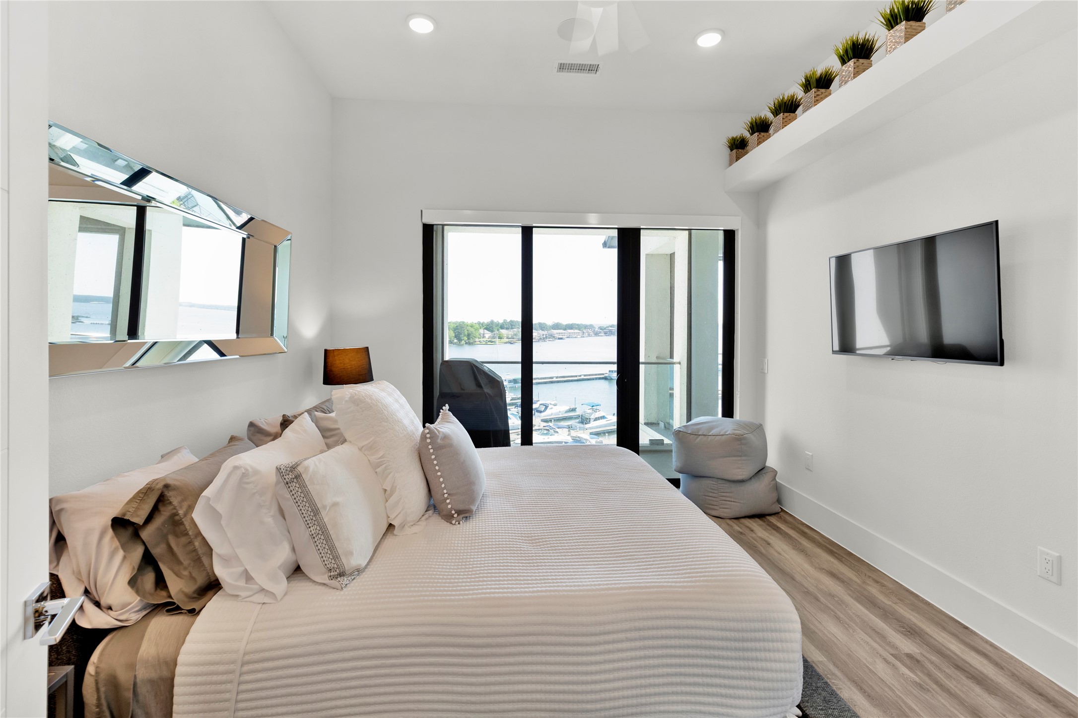 199 Waterpoint Court, Unit 412 Conroe, TX 77304 - Photo 15 of 29 a bedroom with a large bed and a flat tv screen on dresser