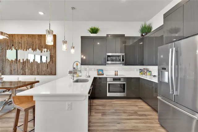 a kitchen with stainless steel appliances a sink stove and refrigerator