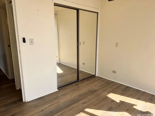 an empty room with wooden floor and entrance