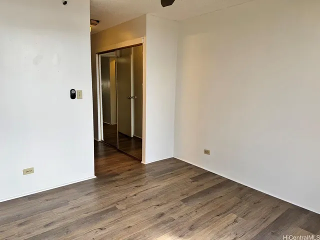 an empty room with wooden floor and closet