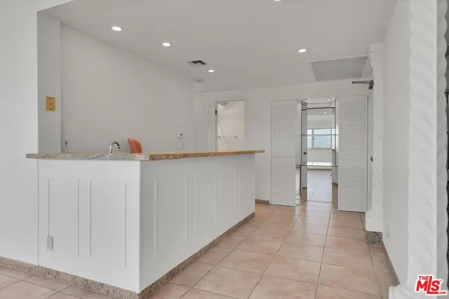 a view of an empty room with wooden floor and entryway
