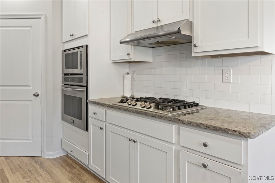 9801 Cravensford Loop Midlothian, VA 23112 - Photo 17 of 49 a kitchen with stainless steel appliances granite countertop white cabinets and a stove