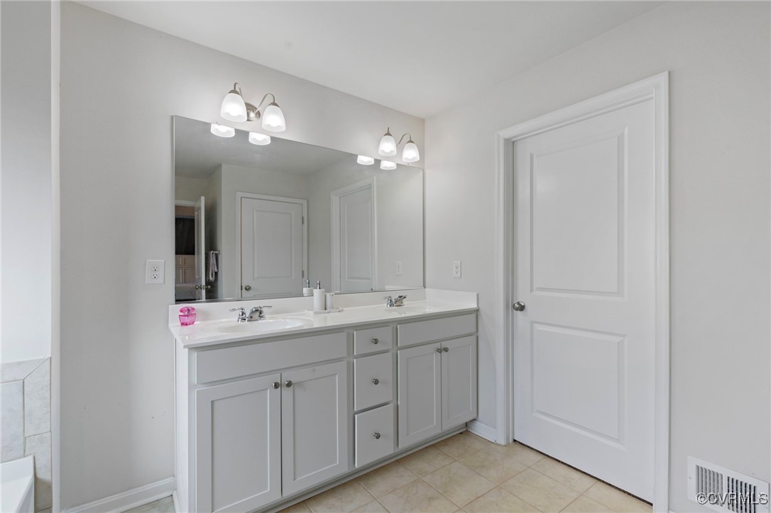 9801 Cravensford Loop Midlothian, VA 23112 - Photo 27 of 49 a bathroom with a double vanity sink and a mirror