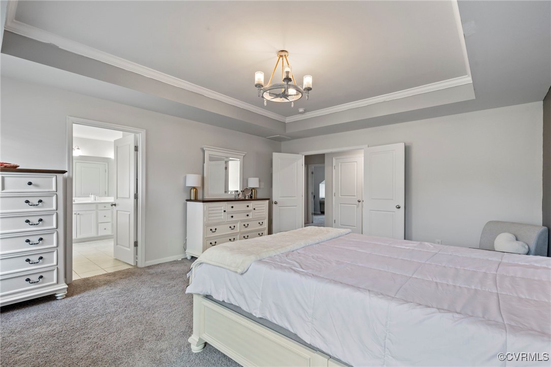9801 Cravensford Loop Midlothian, VA 23112 - Photo 30 of 49 a spacious bedroom with a bed and a chandelier