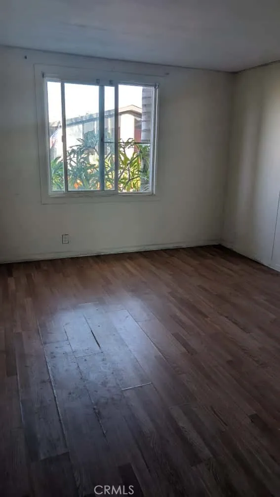 12300 West Lilac Avenue, Unit 714 Santa Ana, CA 92704 - Photo 19 of 22 an empty room with wooden floor and windows