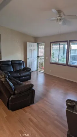 a living room with furniture and a hard wood floor