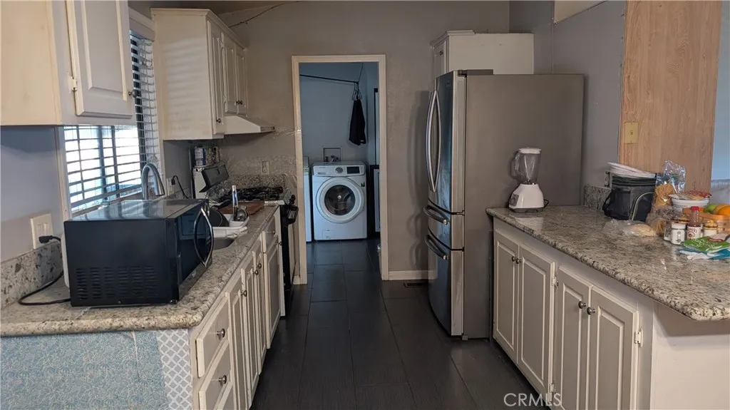 12300 West Lilac Avenue, Unit 714 Santa Ana, CA 92704 - Photo 9 of 22 a kitchen with stainless steel appliances granite countertop a refrigerator a stove a sink and a refrigerator