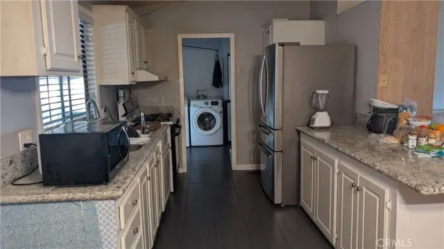 a kitchen with stainless steel appliances granite countertop a refrigerator a stove a sink and a refrigerator