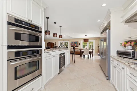 a kitchen with stainless steel appliances kitchen island granite countertop a stove top oven and cabinets