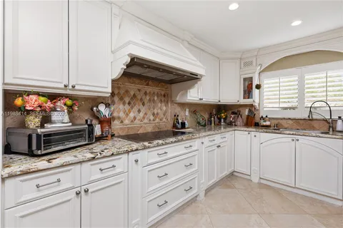 a kitchen with granite countertop white cabinets and white appliances