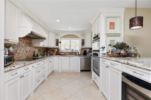a kitchen with granite countertop white cabinets and white appliances