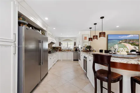 a kitchen with stainless steel appliances granite countertop a refrigerator and a sink