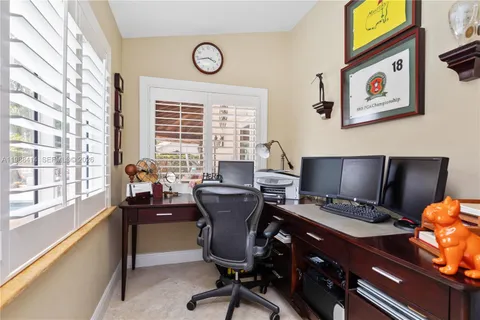 a view of a workspace with furniture and a window