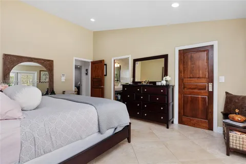 a bedroom with a bed and dresser with mirror