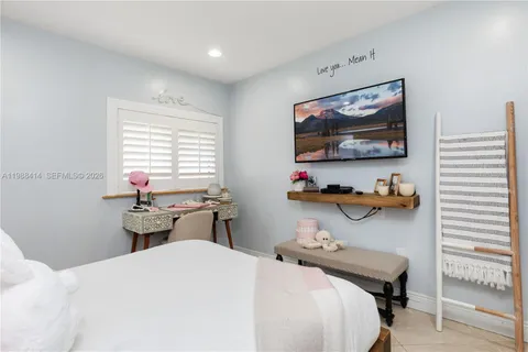 a bedroom with a bed and a flat screen tv
