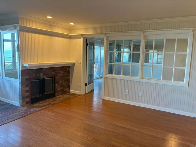 an empty room with wooden floor and fireplace