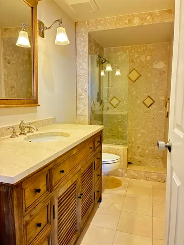 a bathroom with a double vanity sink toilet and shower