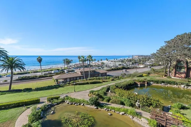 an aerial view of a city with lots of residential buildings ocean and mountain view in back